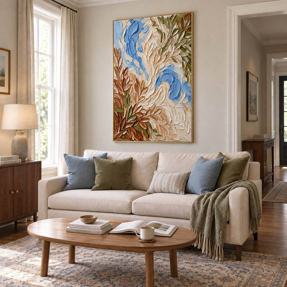 Spring Whispers in a gold frame above a cream sofa with blue and olive cushions in a light-filled living room.