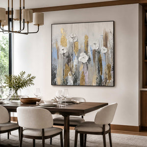 Black framed white floral artwork above a wooden dining table beneath a shaded chandelier.