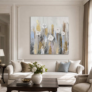 Frameless white floral painting above a cream sofa with pale blue and neutral cushions.