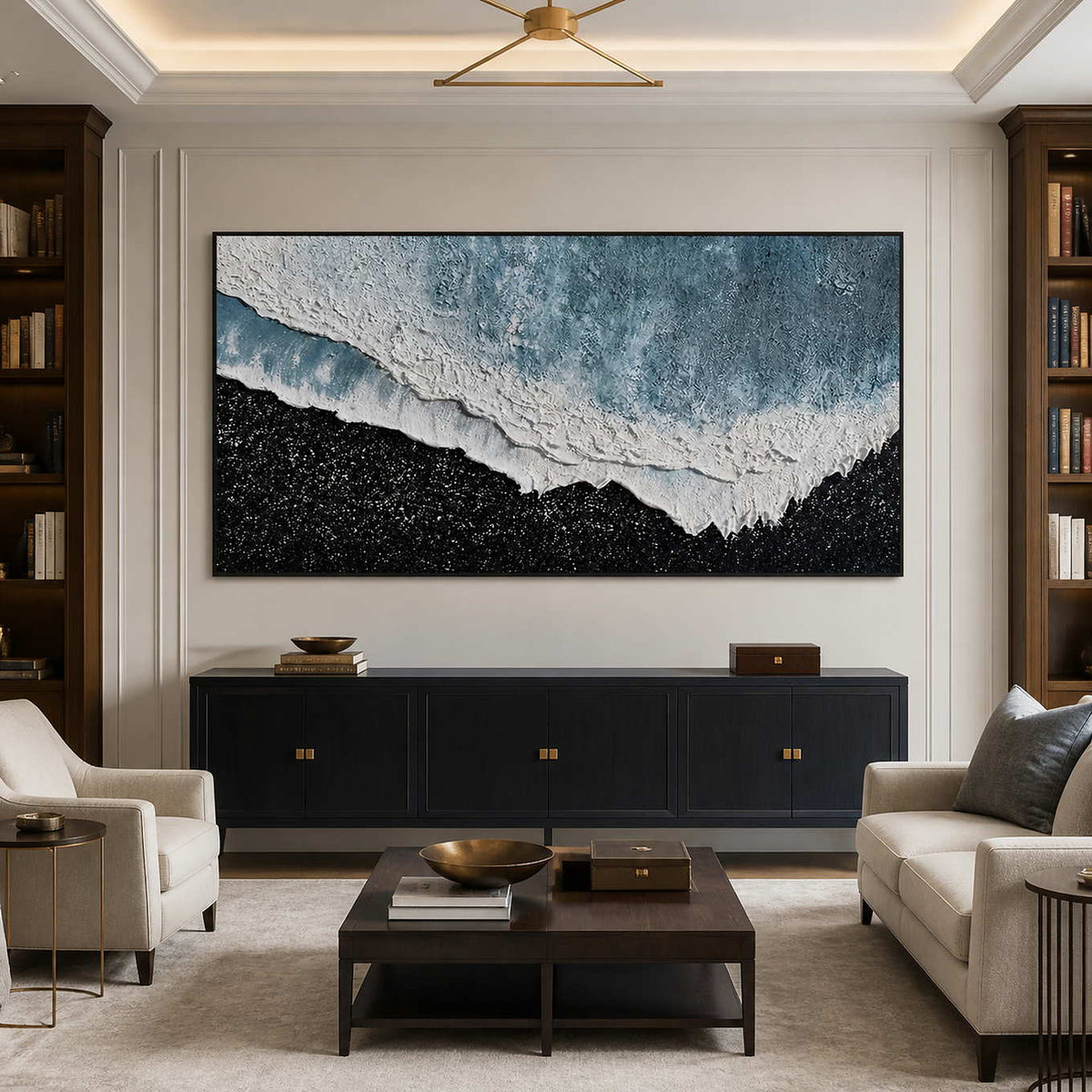 Black framed coastal artwork between bookcases above a dark study lounge cabinet.