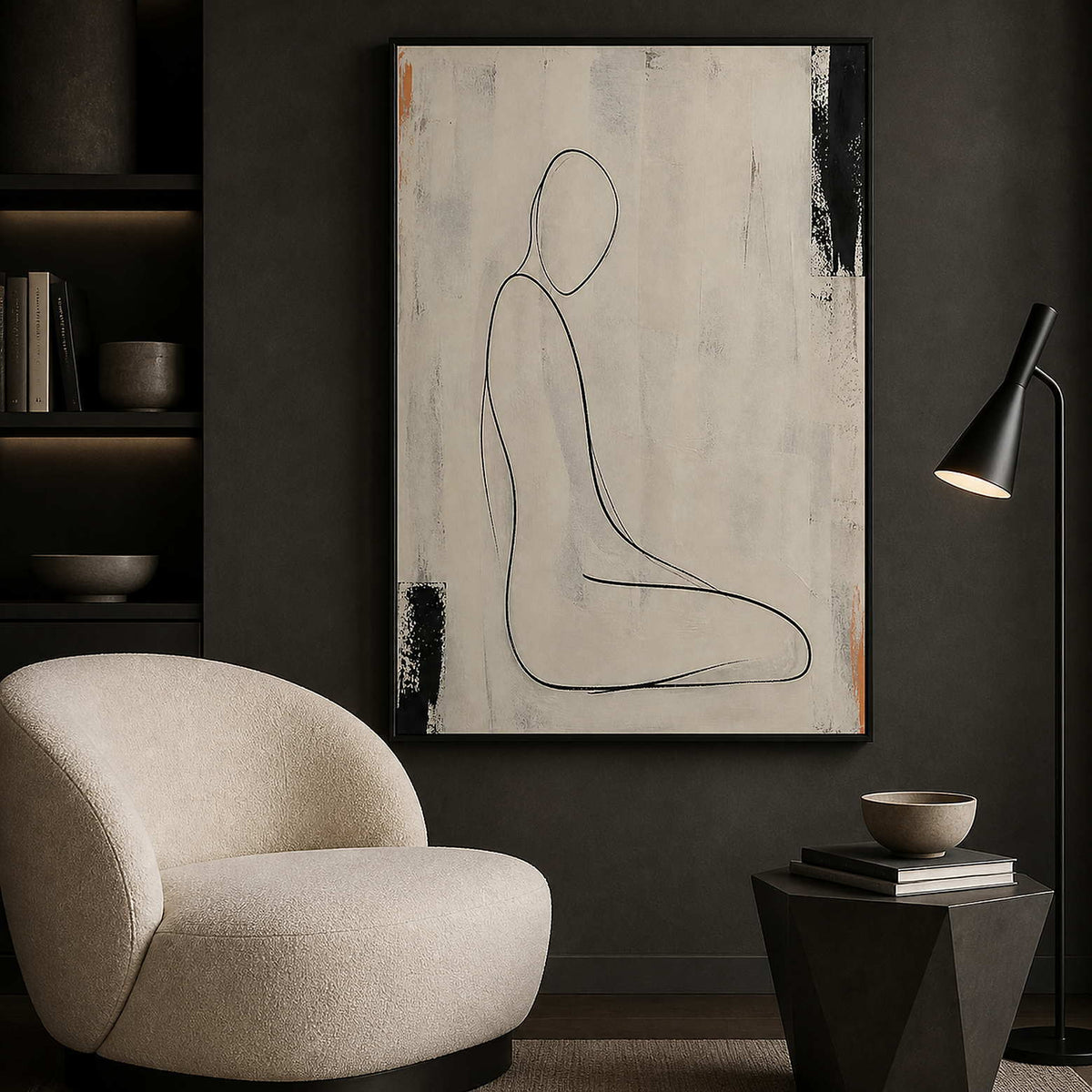 Ivory and black figurative wall art beside a quiet reading chair.