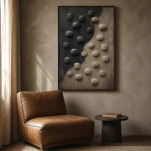 Earthy sculpted wall art beside a caramel leather reading chair.