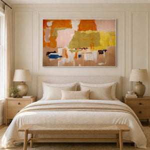 White framed orange and blush abstract artwork above a cream upholstered bed.
