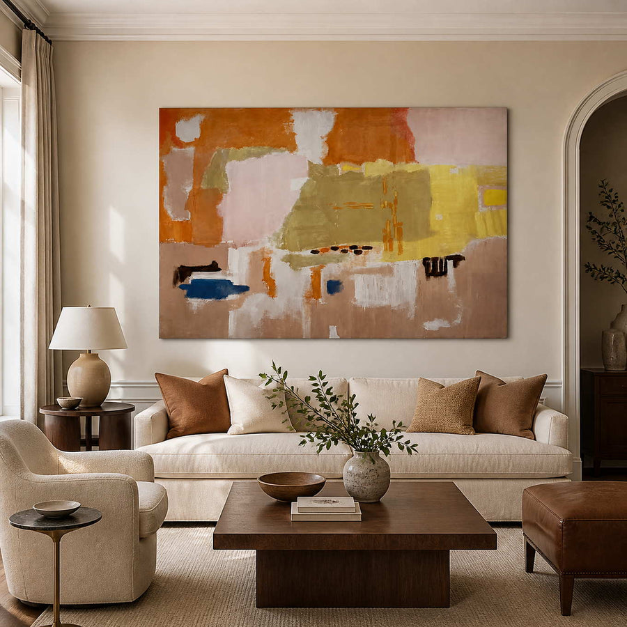 Frameless orange and blush abstract artwork above a cream sofa in warm daylight.