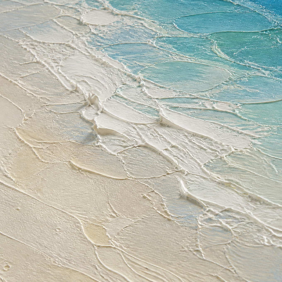 Close-up of turquoise surf meeting warm white hand-painted sand texture.