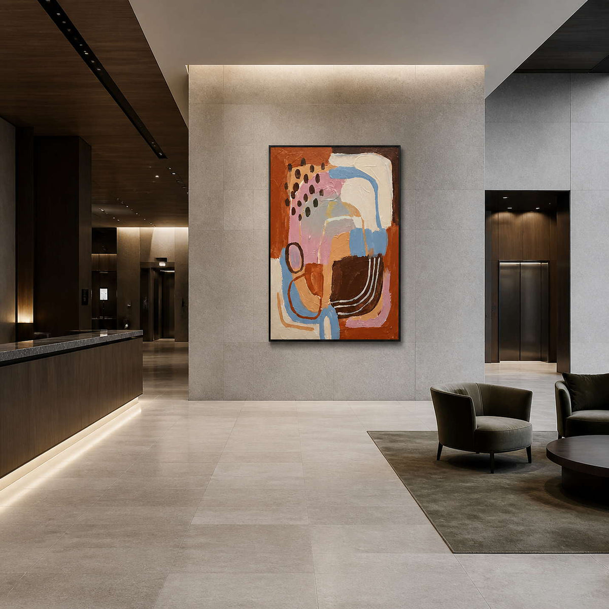 Black framed abstract artwork on a stone lobby wall near elevators and seating.