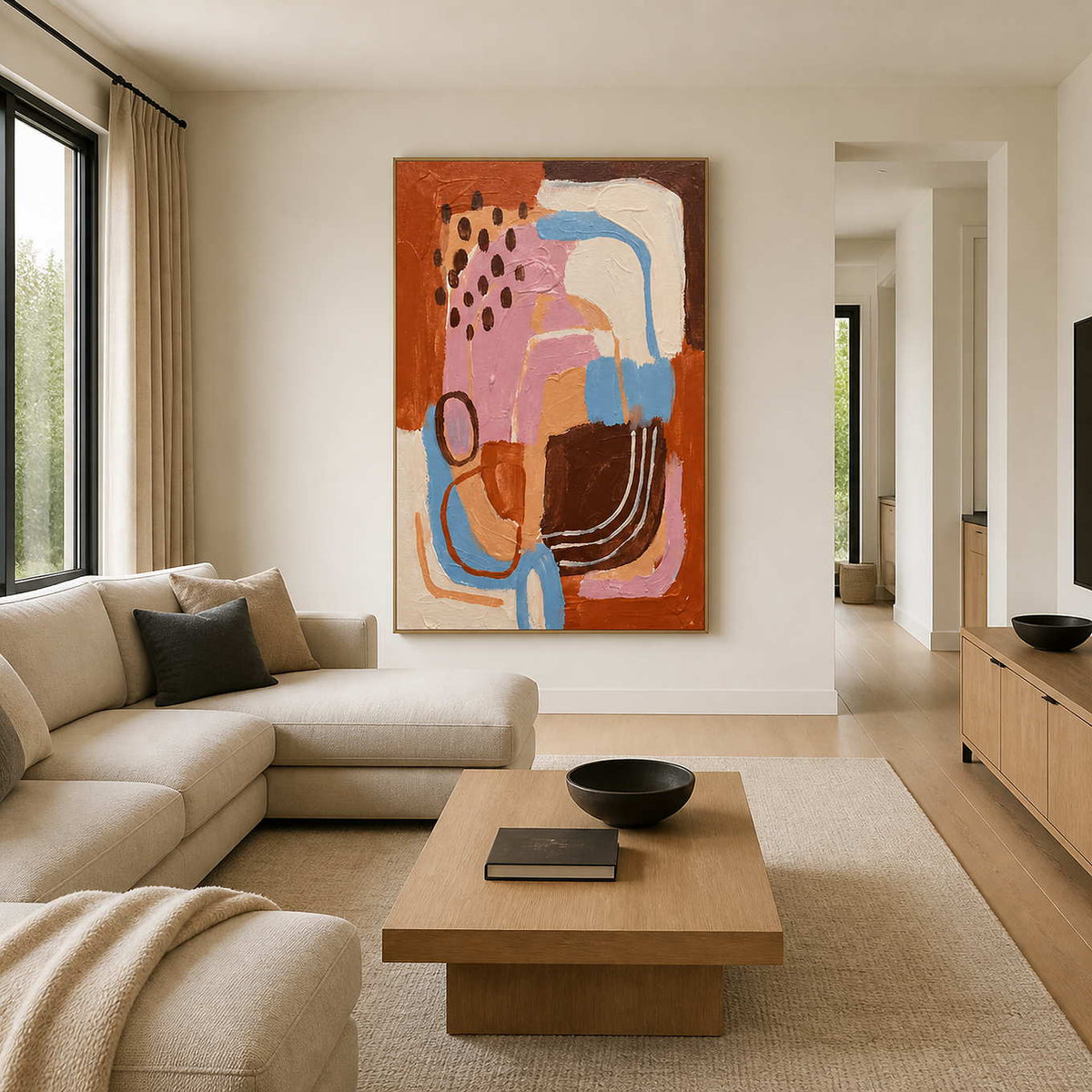 Warm abstract curves in a wood frame beside a cream sectional sofa.