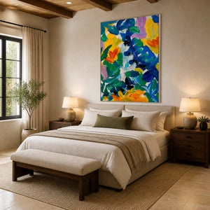 White framed blue-green and yellow floral artwork above a cream bed in a warm bedroom.