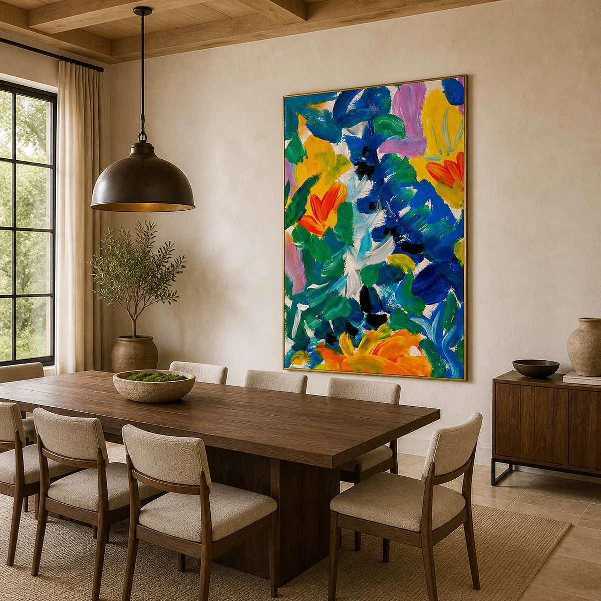 Gold framed summer floral artwork beside a wooden dining table under a dark pendant light.