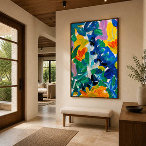 Wood framed vibrant floral artwork above a pale upholstered bench near a glass entry door.