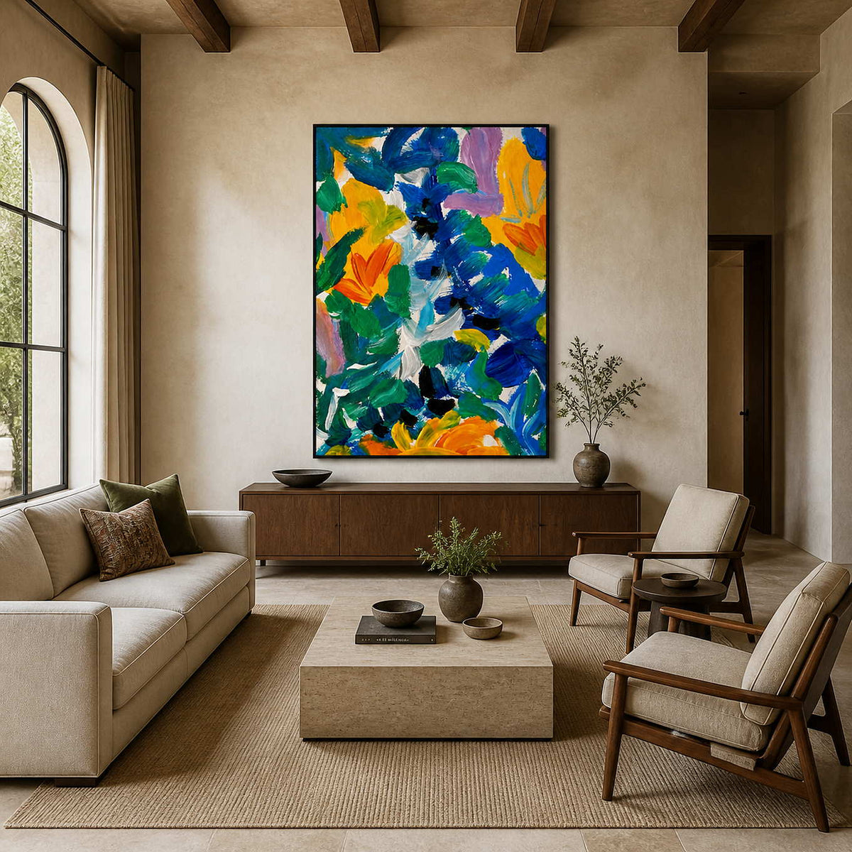Black framed colorful floral artwork above a wooden sideboard between neutral living room seating.