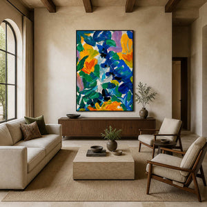 Black framed colorful floral artwork above a wooden sideboard between neutral living room seating.