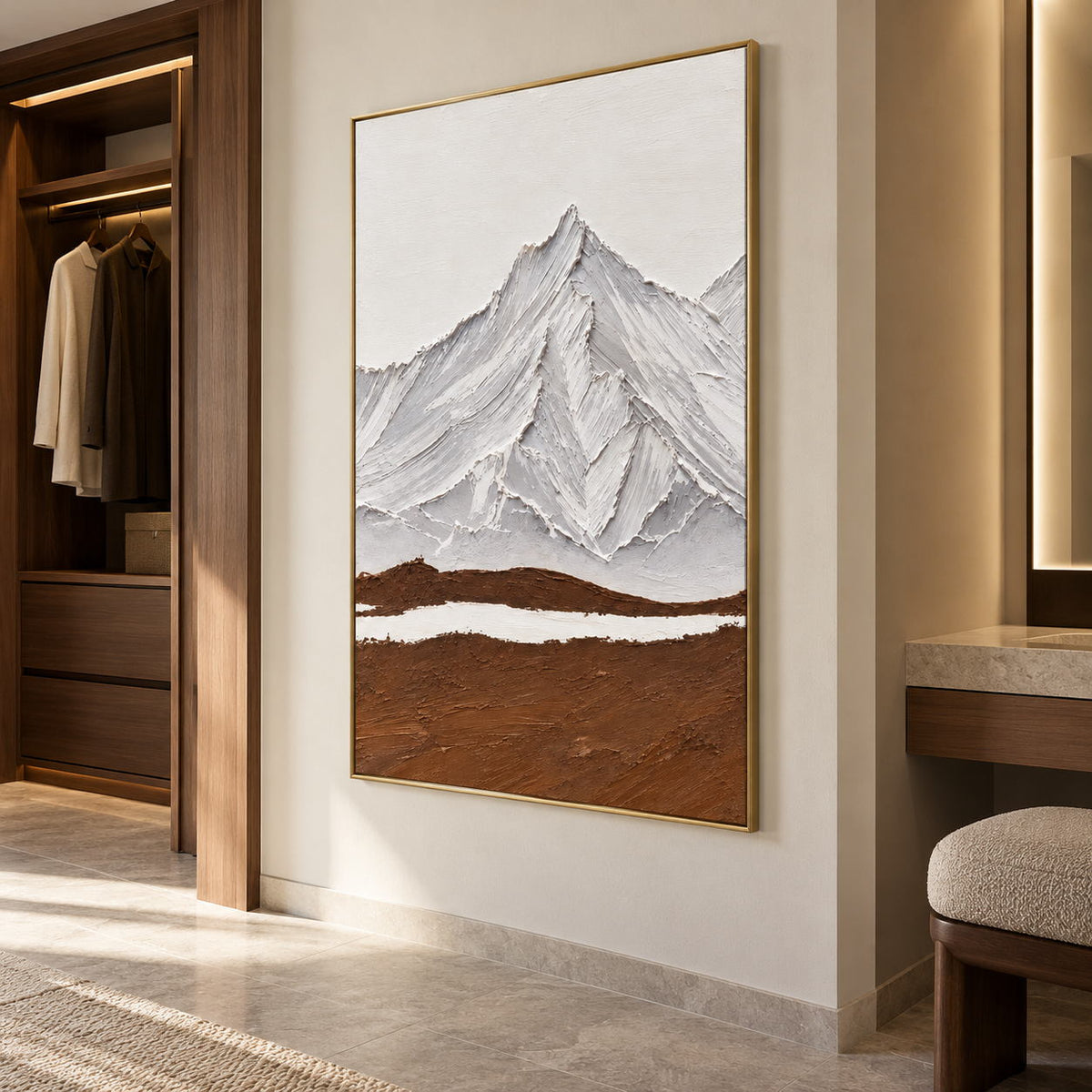 Artwork showing white and gray ridged mountains above a broad brown foreground and a narrow white band beside open wardrobe shelving and a vanity edge, with a gold-colored frame.