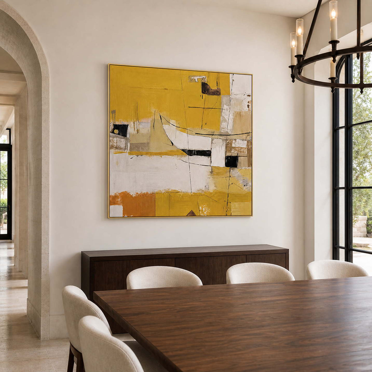 Gold-framed yellow abstract wall art behind a wooden dining table with cream upholstered chairs.