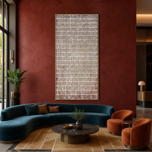 Gold framed narrow abstract painting above curved blue seating in a hotel lobby.