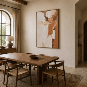 Wood framed cream and tan textured artwork beside a dining table and arched window.