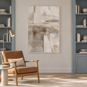 Cream texture artwork near a brown reading chair between blue-gray bookshelves.