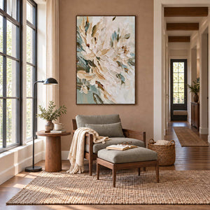 Tenderly in Bloom in a wood frame above a gray reading chair and footstool beside a tall window.