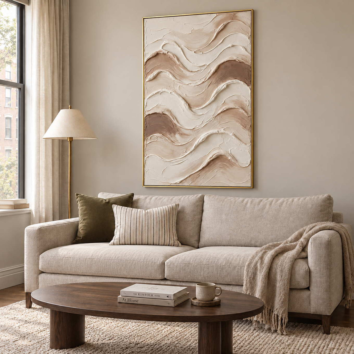Tenderness in a gold frame above a cream sofa with striped and olive cushions and a low wood table.