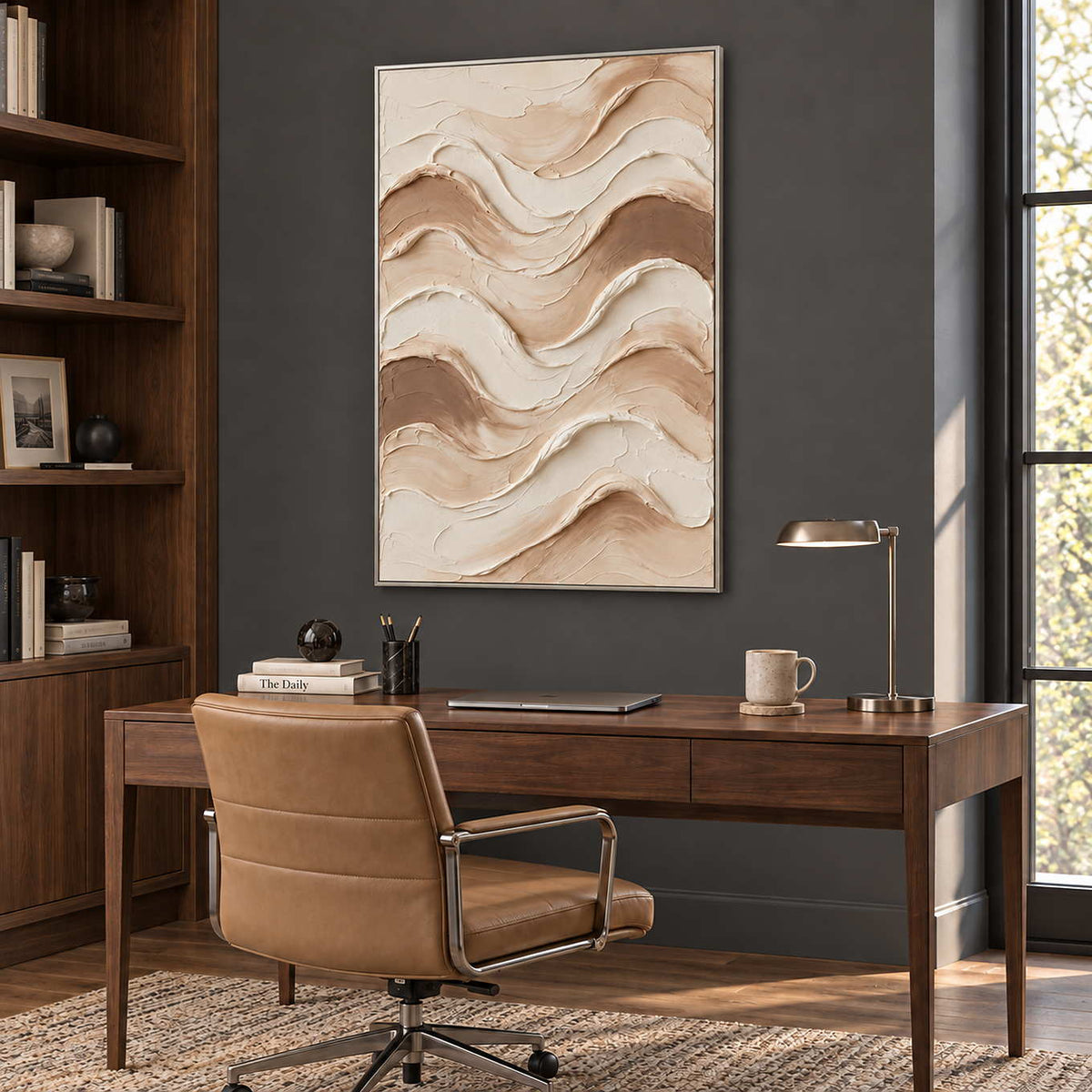 Tenderness in a silver frame above a wood desk and tan leather chair against a charcoal wall.