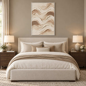 Tenderness in a white frame above an upholstered cream bed with soft beige layered linens.