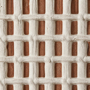 Close-up of irregular raised ivory grid lines over a terracotta underlayer.
