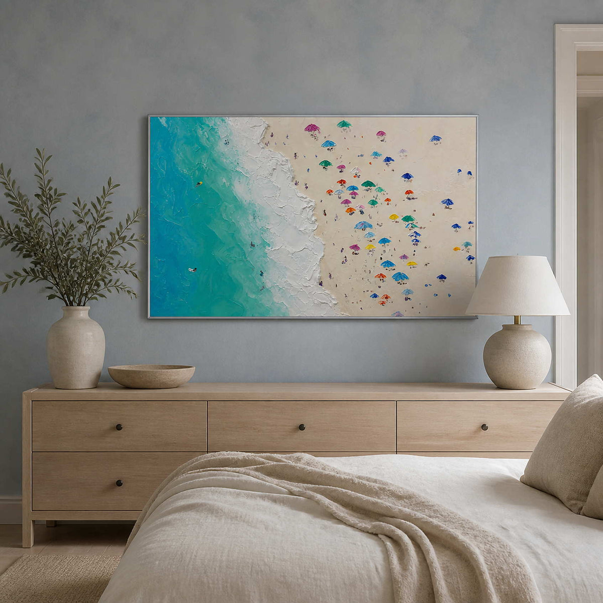 Colorful coastal painting displayed above a mist-blue oak bedroom.