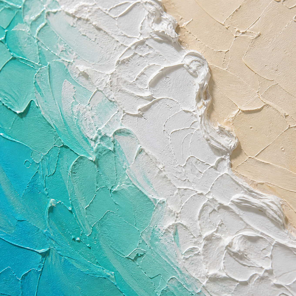 Close-up of turquoise water, white surf, and warm sand texture.