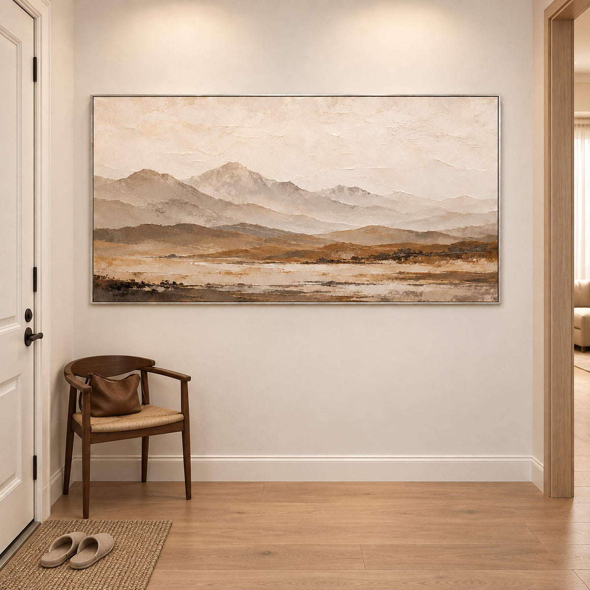 Soft taupe mountains above a muted ochre plain in a silver frame, displayed in an entrance hall.