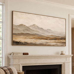 Soft taupe mountains above a muted ochre plain in a brown wood frame, displayed above a fireplace.