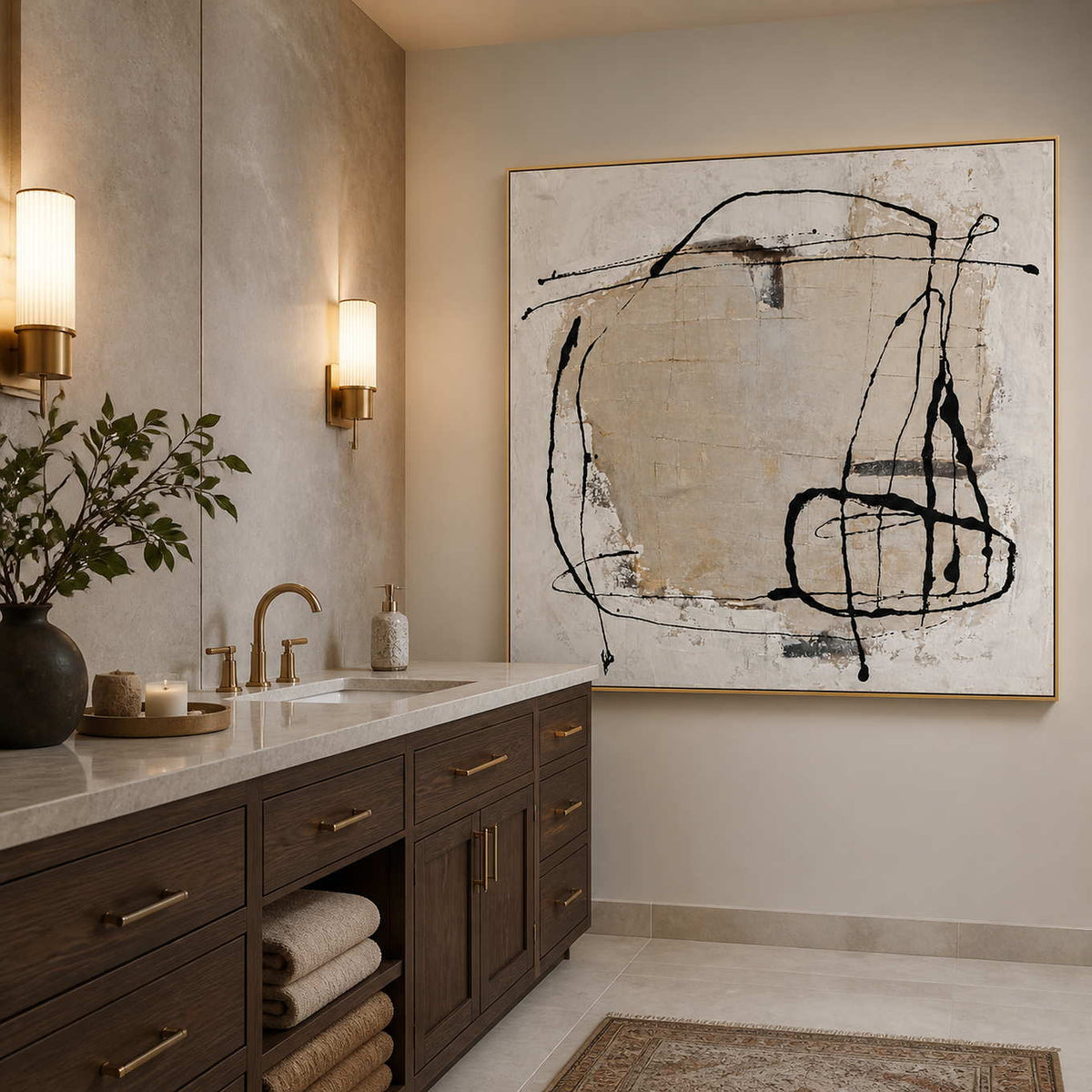 Gold-framed abstract wall art beside a stone vanity in a warm neutral bathroom.
