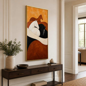 Gold framed horse painting above a slim wooden console in a bright hallway.