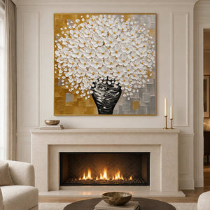 Gold-toned framed bouquet artwork above a cream fireplace with candles on the mantel.