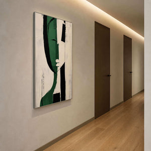 Black and green abstract artwork viewed along a warm hallway.