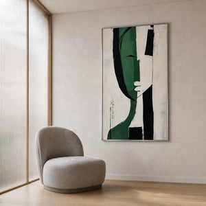 Modern green wall art beside a soft chair in a reading nook.