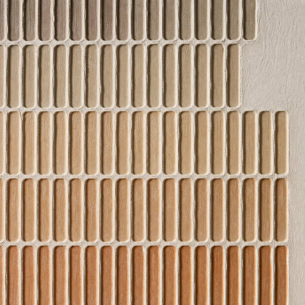 Close-up of raised stone, sand, and terracotta grid texture.