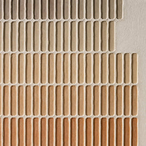 Close-up of raised stone, sand, and terracotta grid texture.