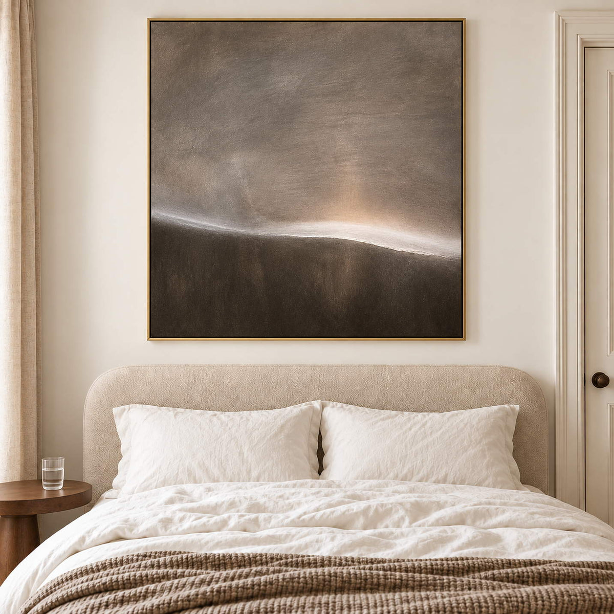A thin glowing horizon between smoky gray and dark brown fields in a gold frame, displayed above a bed.