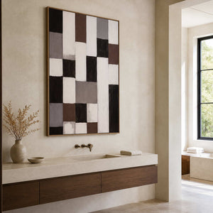Wood framed geometric abstract artwork above a pale stone vanity with a wooden cabinet.