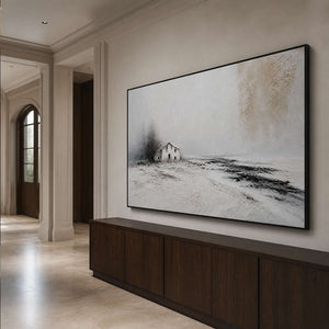 Textured snowy house wall art in an elegant entryway with a black frame.