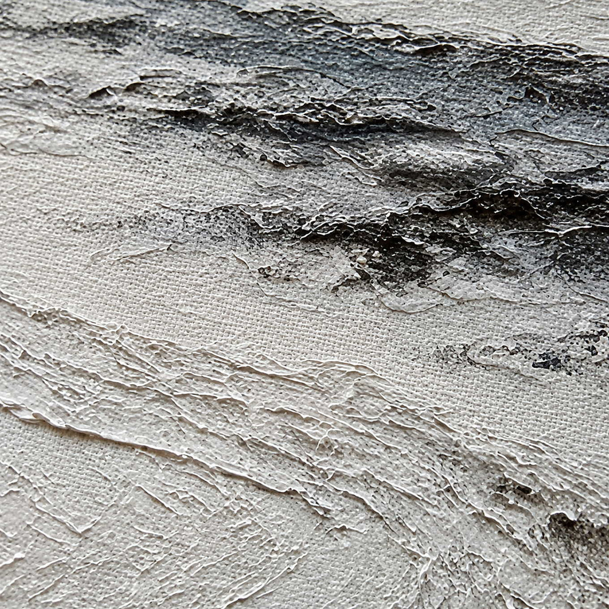 Close-up of layered ivory snow and charcoal field texture.