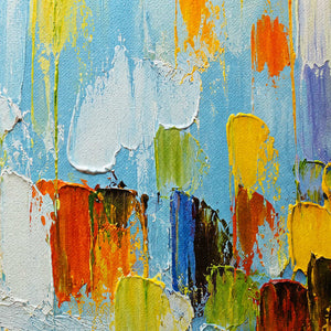 Close-up of layered sky blue, yellow, orange, green, and deep blue paint texture.