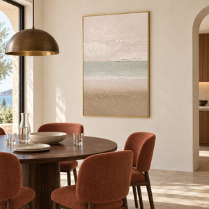 Hand-painted coastal canvas in warm ivory, sea-glass green, and sand, displayed in a dining room in a gold frame.