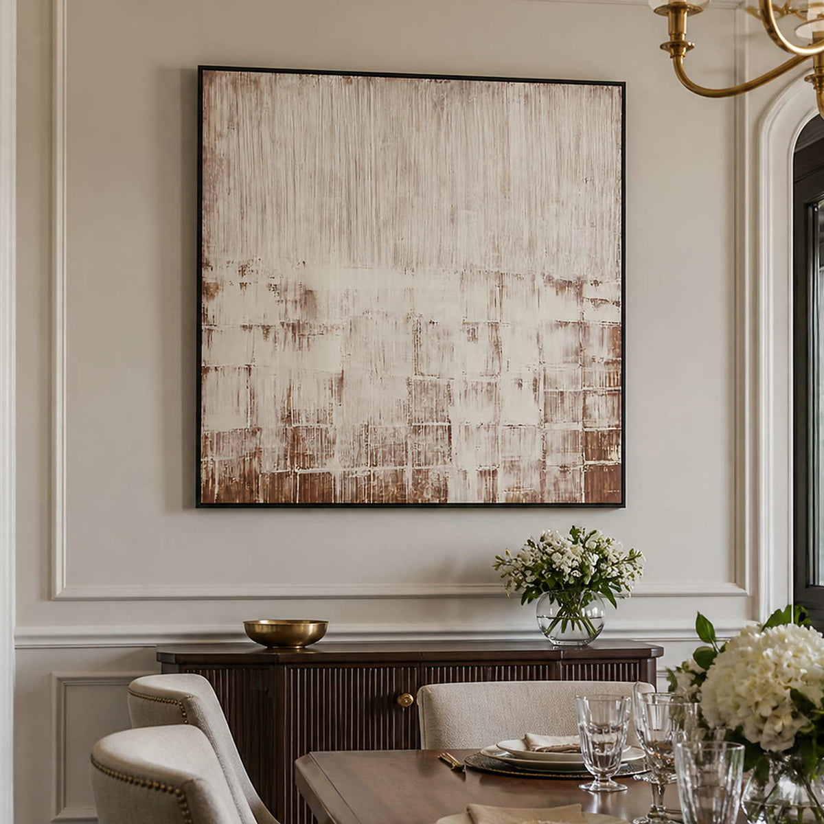 Black framed cream and brown abstract artwork above a dining room sideboard.