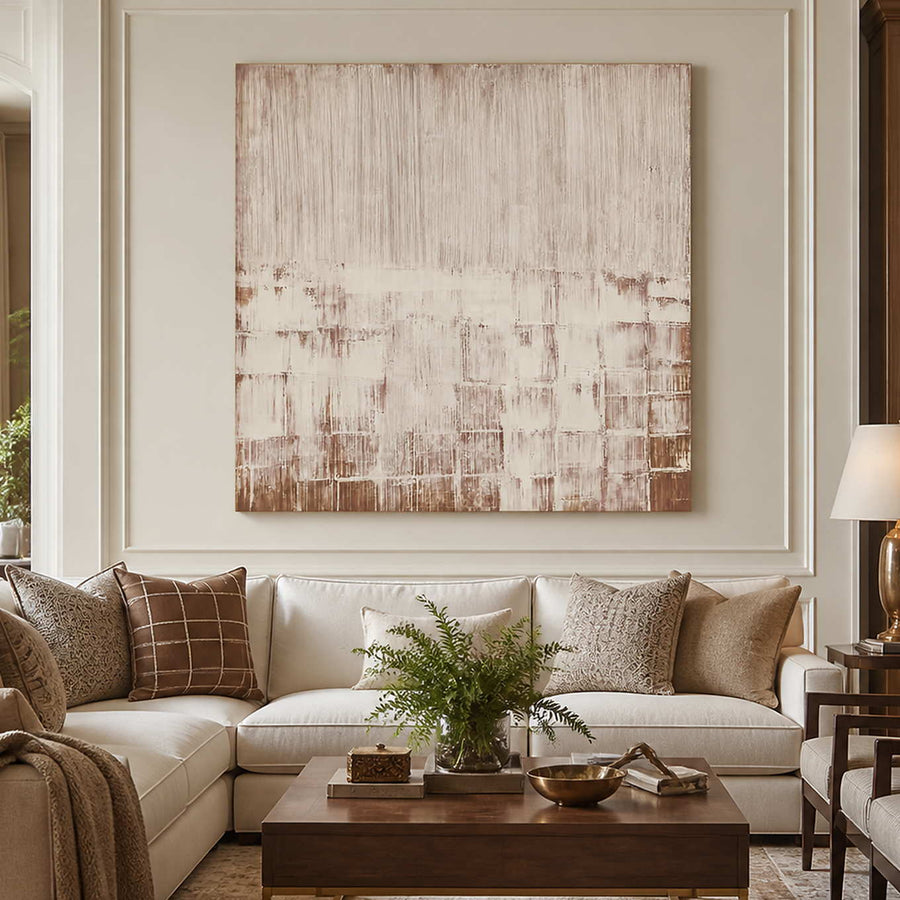 Frameless cream and brown abstract artwork above a sectional sofa with neutral cushions.