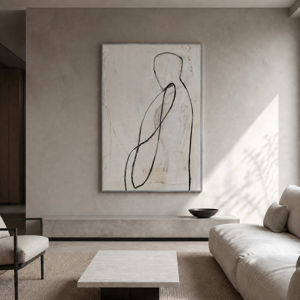 Neutral figurative artwork displayed in a softly plastered residential living room.