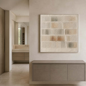 Warm white textured wall art displayed in a pale stone bathroom area.
