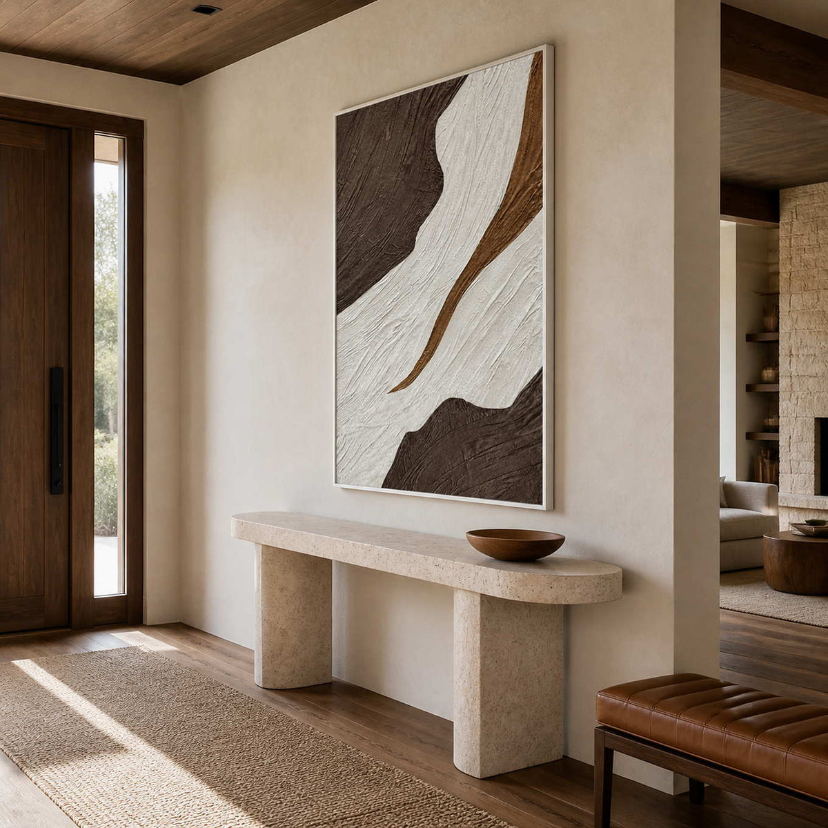 White-framed textured abstract wall art above a stone console beside an entry door.