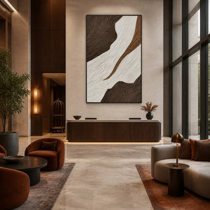 Black-framed textured abstract wall art above a reception counter in a spacious hotel lobby.