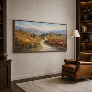 Warm landscape wall art shown from the left in a nature-inspired reading room.